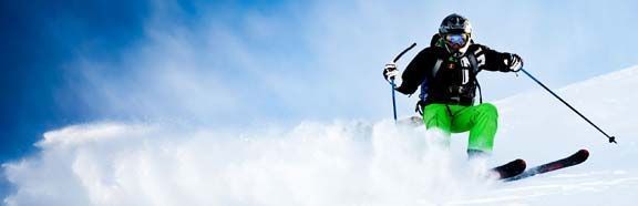 Skier in fresh snow with Lussari sport ski equipment